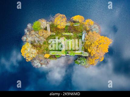 Aviemore, Scotland, UK. 29th October 2022.  Aerial view of spectacular late autumn colours and reflections of clouds  around ruined castle on island on Loch an Eilein in the Rothiemurchus estate in Cairngorms National Park near Aviemore in Scottish Highlands.  Iain Masterton/Alamy Live News Stock Photo
