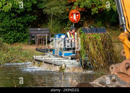 A small dredger clearing out a small lake in Wales Stock Photo