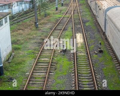 railway station. Rails with sleepers on top. Puddles between the rails. Abandoned place. Old station. Cargo transportation. industrial zone Stock Photo