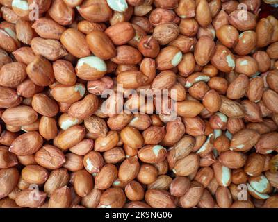 Lots of peanuts. Background from peanut without shell. Snack on the table. Squirrel food. Lots of nuts. Hearty ingredient. Tasty food. Counter in the Stock Photo