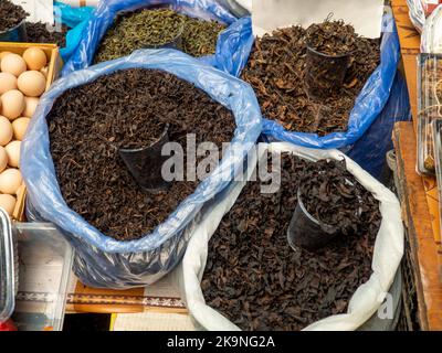 Bags with different types of tea on the market. Packing and sale of leaf tea. Weight tea. Drink ingredient. Different varieties Stock Photo