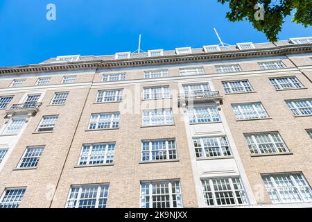 Looking up apartment flats house building l architecture in Mayfair, Westminster of London UK by Park lane street road near Hyde park Stock Photo