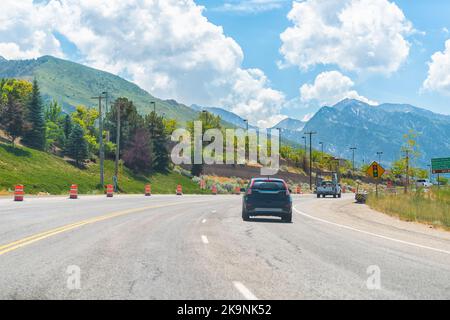 Cars driving on interstate highway road at Park City, Utah ski resort town with Wasatch mountains in summer background Stock Photo