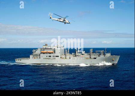 An MH-60S Sea Hawk helicopter assigned to Helicopter Sea Combat Squadron (HSC) 21 maneuvers toward the Military Sealift Command dry cargo and ammunition ship USNS Cesar Chavez (T-AKE 14) Stock Photo