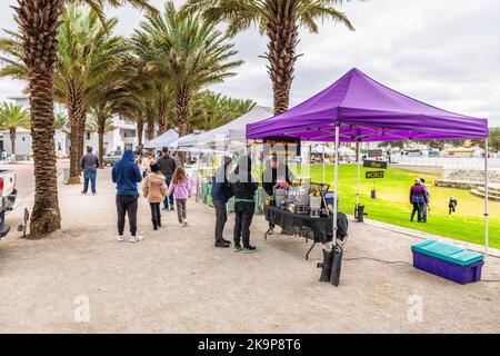 Seaside, USA - January 9, 2021: Seaside Florida farmers market in winter with people walking by market vendor stalls selling food and seasoning Stock Photo