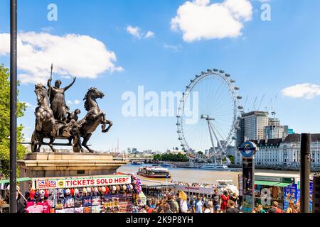 London, United Kingdom - June 22, 2018: Westminster pier ticket kiosk for boat tour on Thames river, Millennium eye wheel, Boudiccan rebellion statue Stock Photo