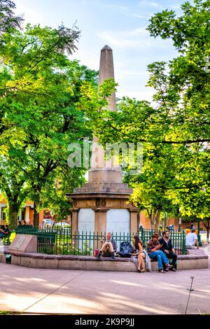Santa Fe, USA - June 14, 2019: People at Santa Fe plaza park with Soldiers' memorial obelisk for US soldiers fallen in fight with native americans Stock Photo