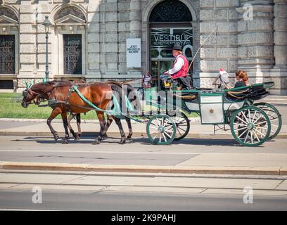 Vienna, Austria - June 2022: Tourists in a horse drawn Carriage Tour . Tourist activity in Vienna Stock Photo