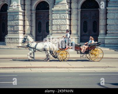 Vienna, Austria - June 2022: Tourists in a horse drawn Carriage Tour . Tourist activity in Vienna Stock Photo