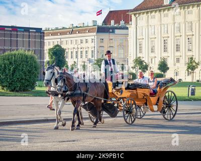 Vienna, Austria - June 2022: Tourists in a horse drawn Carriage Tour . Tourist activity in Vienna Stock Photo