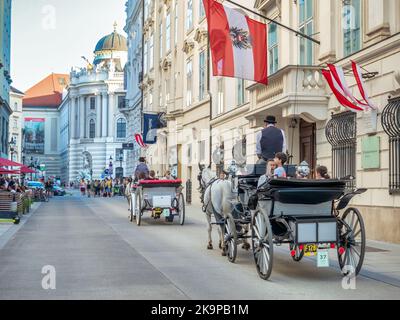 Vienna, Austria - June 2022: Tourists in a horse drawn Carriage Tour . Tourist activity in Vienna Stock Photo