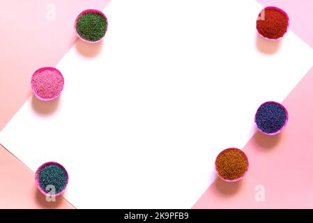 Colorful glass beads. A variety of shapes and colors to make a beaded necklace or string of beads for women. box on pink and white background. A rainbow of colorful seed beads ready for beading Stock Photo