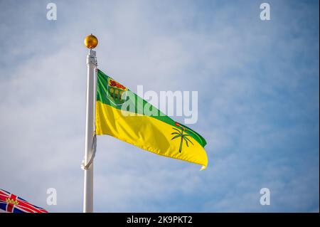 Flag of Saskatchewan on flagpole against the blue sky Stock Photo