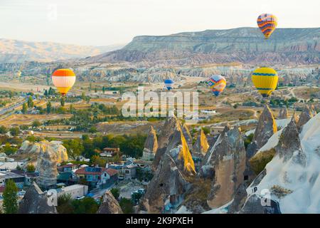 10.11.2022 Cappadocia, Turkey. Several hot air balloons in vivid colors flying over peaceful Turkish city of Cappadocia. Aerial view of interesting landscape and famous caves. High quality photo Stock Photo
