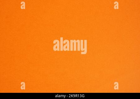 Closeup photo of cardboard sheet surface in orange color. Unicolor background. Stock Photo