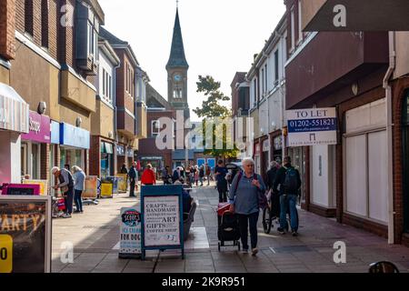 A view along Saxon Square in Christchurch, UK, a shopping centre where many shops have advertising boards outside. Stock Photo