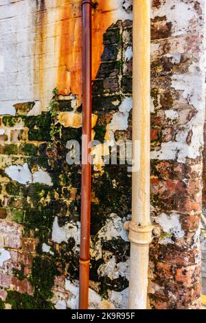 A weathered and worn section of wall with flaking paint and render i ...
