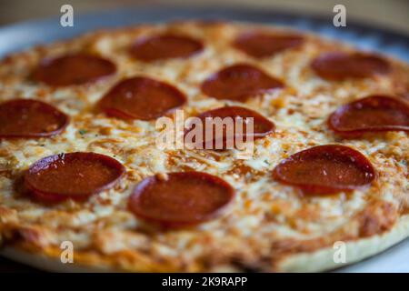 Baked pepperoni and cheese thin crust pizza Stock Photo