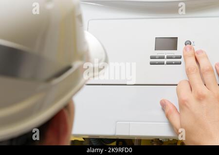 Setting up and servicing by a service department. Adjustment of gas boiler at domestic home. Stock Photo