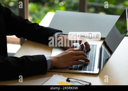 Business Contact Us concept, Hands typing on keyboard computer with communication contact icon, E-mail, Phone number, Social media chatting message. Stock Photo