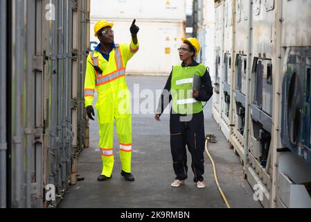 Young worker people working job at a warehouse,  Industrial Engineers, Safety Supervisors and Foremen in Hard Hats and Safety Vests Walking in Shippin Stock Photo