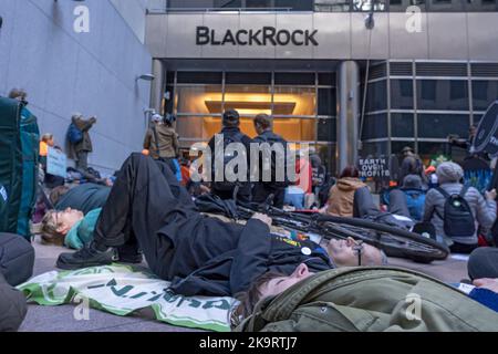 New York, USA. 29th Oct, 2022. Climate activists in act a die-out in front of the headquarters of financial investment firm BlackRock during an 'Occupy Park Avenue' protest on October 29, 2022 in New York City.   Dozens of climate activists with a large banner reading 'Occupy Park Avenue' and placards targeting the fossil fuel industry marched along Park Ave from JPMorgan Chase bank's new headquarters to the headquarters of financial investment firm BlackRock to protest these companies investment in fossil fuels. Credit: Ron Adar/Alamy Live News Stock Photo