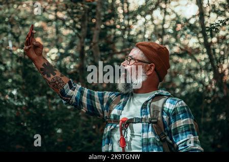 A Man Taking Selfie While Walking Through The Forest In Autumn Stock Photo