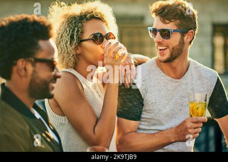 Having the times of their life. a group of young friends having a drink and spending the day outside on a rooftop. Stock Photo