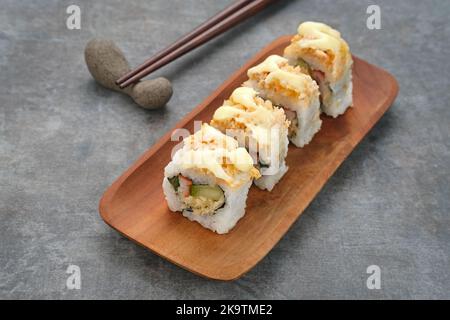 Sushi Rolls Mayo with crab stick, ebi, cucumber served on wooden plate Stock Photo
