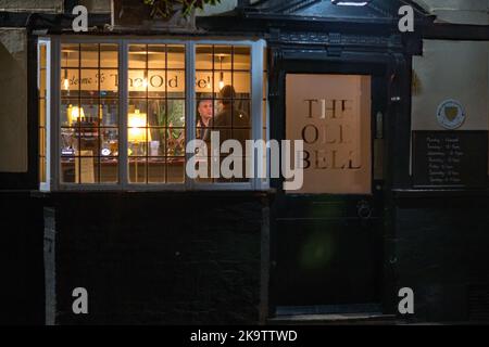 :The Old Bell pub on Bell street in Sawbridgeworth, an evening view through the front window of the landlord serving Stock Photo