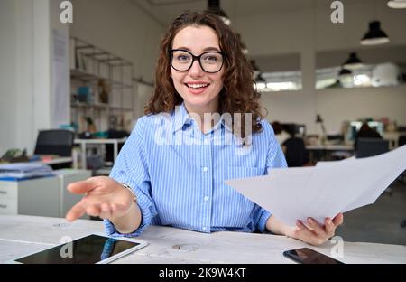 Young business woman manager talking to web camera on virtual meeting. Stock Photo
