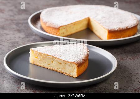 piece of traditional Greek yogurt cake Yaourtopita closeup in a plate on a table. Horizontal Stock Photo