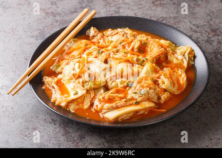 Kimchi is a traditional Korean side dish of salted and fermented vegetables, such as napa cabbage, carrot and Korean radish with spices closeup on the Stock Photo