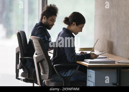 Two Indian office employees working seated at table Stock Photo