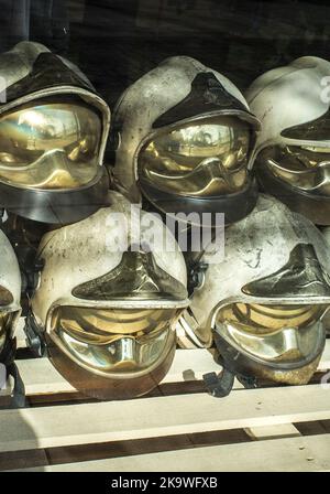 Pile of old firefighter helmets. Obsolete firefighter equipment Stock Photo