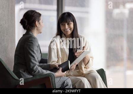 Meeting in office of two happy businesswomen with digital tablet Stock Photo