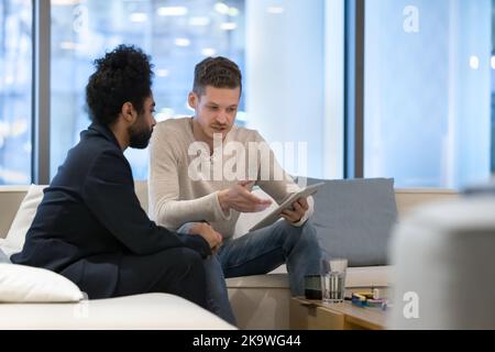 Two multiethnic businessmen use digital tablet in office Stock Photo