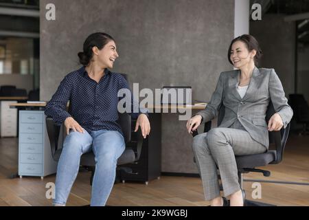 Happy women office employees laughing having fun at workplace Stock Photo