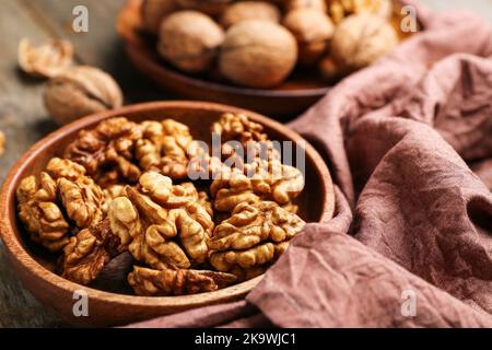 Plate of walnut kernels on wooden table, closeup Stock Photo