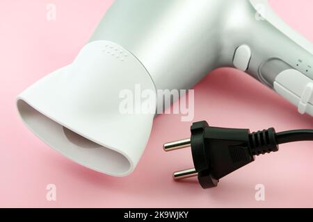 Hairdryer and cable on pink background close up Stock Photo