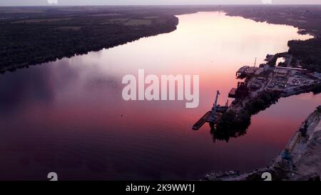 Aerial drone footage of small port next to shipyard, ship repair area, cranes, cargo ship port. download image Stock Photo