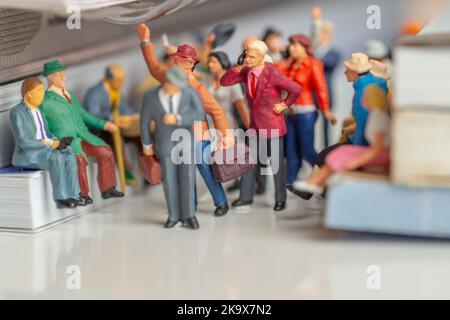 Miniature toys of man and woman with mobile phones talking in a public transportation medium concept - lack of manners Stock Photo