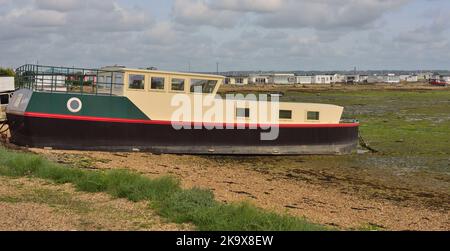 One of the houseboats beside The Kench on Hayling Island at low tide. Stock Photo