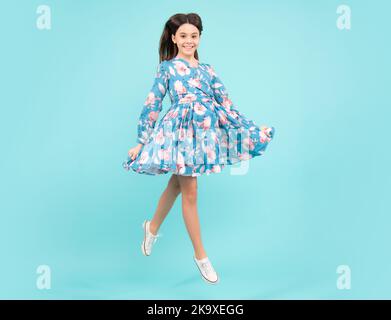 Happy teenager, positive and smiling emotions. Full length overjoyed teenager kid girl 12 13 14 year jumping old isolated on blue background studio Stock Photo