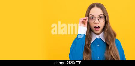 Surprised teenage girl fix eyeglasses yellow background, surprise. Child face, horizontal poster, teenager girl isolated portrait, banner with copy Stock Photo