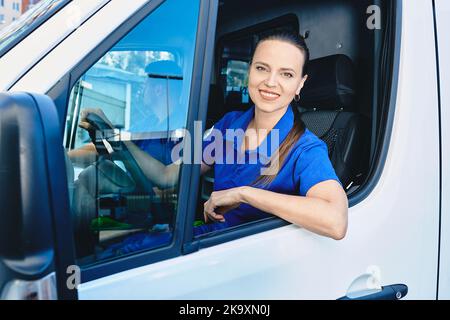 Portrait of female paramedic sitting inside ambulance. EMS worker Stock Photo