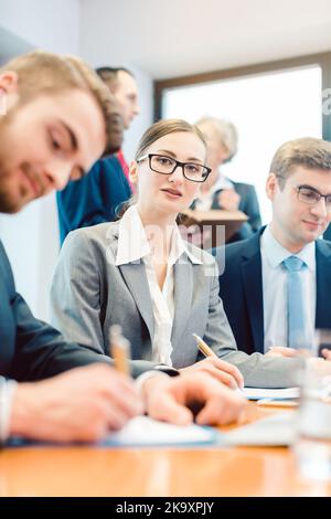 Business woman amidst team working in office Stock Photo - Alamy