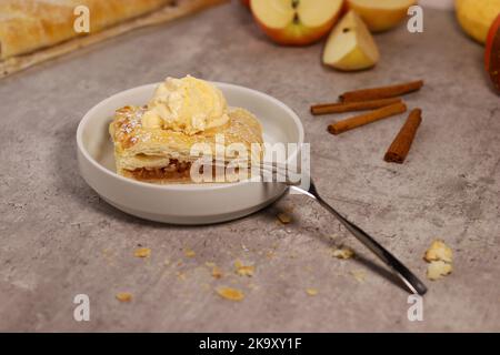 piece of an apple strudel roll with cinnamon and ice cream on top Stock Photo