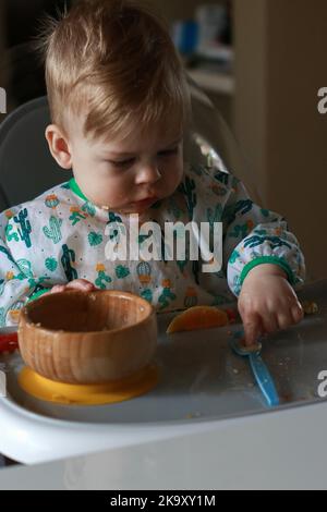 baby eating by himself learning through the Baby-led Weaning method Stock Photo