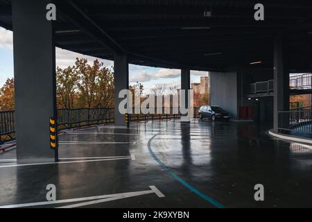 Inside circle multilevel parking, view on golden autumn city park, downtown transport infrastructure in Kharkiv, Ukraine Stock Photo